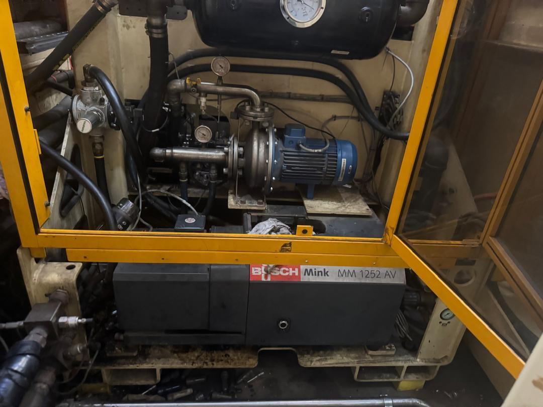 PENCO engineer servicing a Busch Mink vacuum pump package on a client site