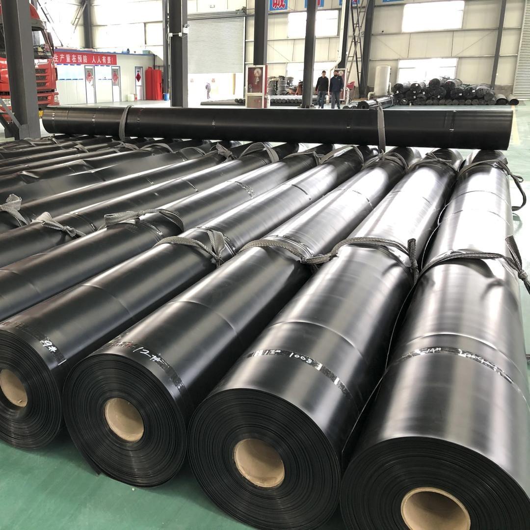 Rolls of HDPE geomembrane liner stacked in a warehouse